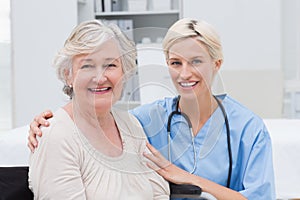 Nurse with arm around senior patient in clinic