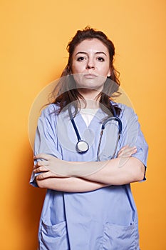 Nurse with arms crossed looks at camera