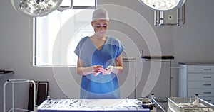 Nurse arranging surgical tools on tray