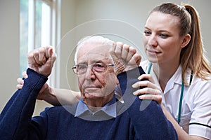 Nurse Assessing Stroke Victim By Raising Arms