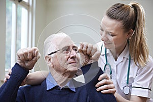 Nurse Assessing Stroke Victim By Raising Arms