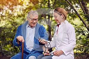 Nurse assessment of blood pressure elderly smiling man