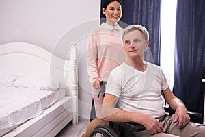 Nurse assisting disabled man.