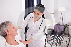 Nurse assisting disabled man.