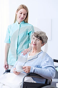 Nurse assisting disabled senior woman