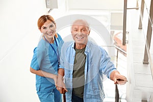 Nurse assisting elderly man on stairs