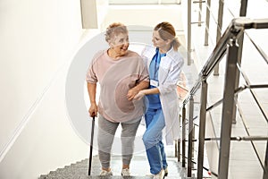 Nurse assisting elderly woman on stairs