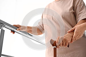 Nurse assisting elderly woman on stairs indoors