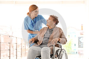 Nurse assisting elderly woman in wheelchair