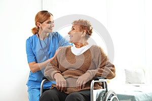 Nurse assisting elderly woman in wheelchair