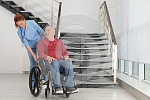 Nurse assisting senior man in wheelchair