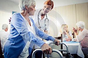 Nurse assisting a senior using a walker