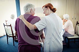 Nurse assisting a senior using a walker