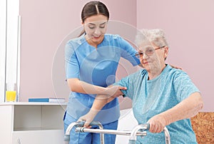Nurse assisting senior woman with walker