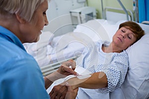 Nurse attaching iv drip on patients hand