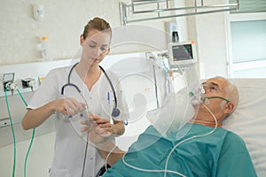 Nurse attaching pulse monitor to elderly patient