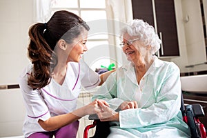 Nurse attending senior woman in a long term care facility, concept of trust