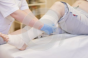 Nurse bandages the leg. photo