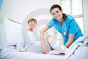 Nurse bandaging leg of patient