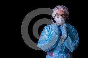 A nurse on a black background in a protective uniform