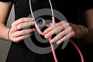 Nurse with Black Uniform and Pink Medical Stethoscope on Black Background