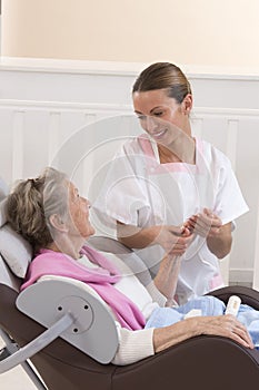 Nurse or caregiver assists an elderly woman with skincare