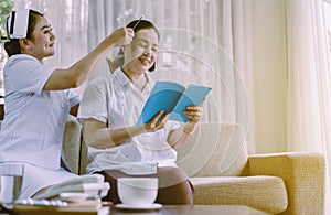 Nurse or caregiver using combing to hair senior asian patient woman,Nursing home care concept