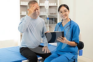 A nurse in charge takes care of a senior man to sleep in a room at the hospital department. Asian female doctor talking