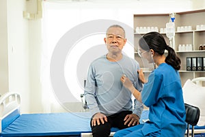 A nurse in charge takes care of a senior man to sleep in a room at the hospital department. Asian female doctor talking