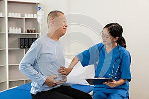 A nurse in charge takes care of a senior man to sleep in a room at the hospital department. Asian female doctor talking