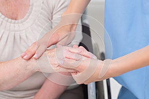 Nurse checking flexibility of patients wrist in clinic