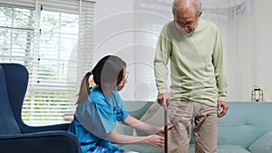 Nurse checking knee and leg after surgery of senior old man patient suffering from pain in knee