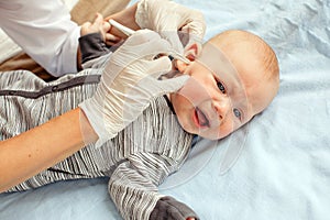 Nurse cleaning ear of newborn baby