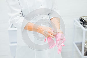 Nurse at the clinic putting on rubber gloves
