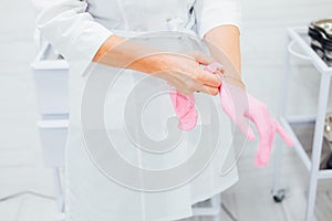 Nurse at the clinic putting on rubber gloves