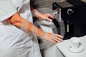 Nurse in cosmetic beauty parlour making coffee