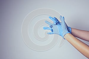 Nurse or cosmetologist putting on medical latex glove isolated. Copy space