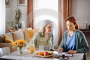 Nurse cosulting with senior her health condition.