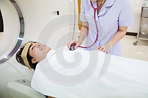 Nurse is counting heart rate. doctor using a stethoscope to listen to man patient`s chest checking heartbeat or lung in medical cl