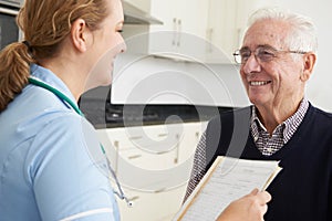 Nurse Discussing Medical Record With Senior Male Patient