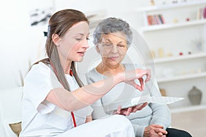 Nurse discussing medication with elderly woman