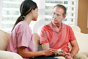 Nurse Discussing Records With Senior Male Patient