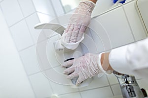 A nurse disinfects an item in a hospital room