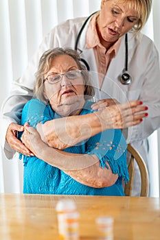Nurse or Doctor Helping Senior Adult Woman With Arm Exercises