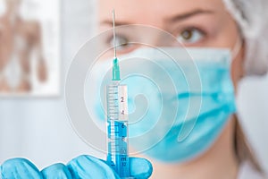 Nurse or doctor holding an injection needle .