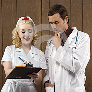 Nurse and doctor looking at clipboard.
