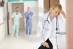 nurse doctor with migraine overworked overstressed in hospital hall corridor