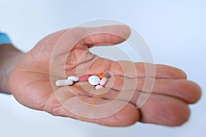 nurse, doctor, patient holds drugs in hand, hand stretches on palm pills, capsules, vitamins, drugs in male palm on light