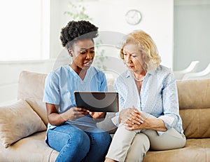 nurse doctor senior care tablet computer technology showing caregiver help assistence retirement home nursing elderly