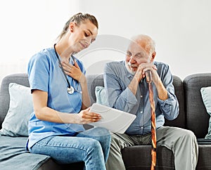 nurse doctor senior care tablet computer technology showing caregiver help assistence retirement home nursing elderly